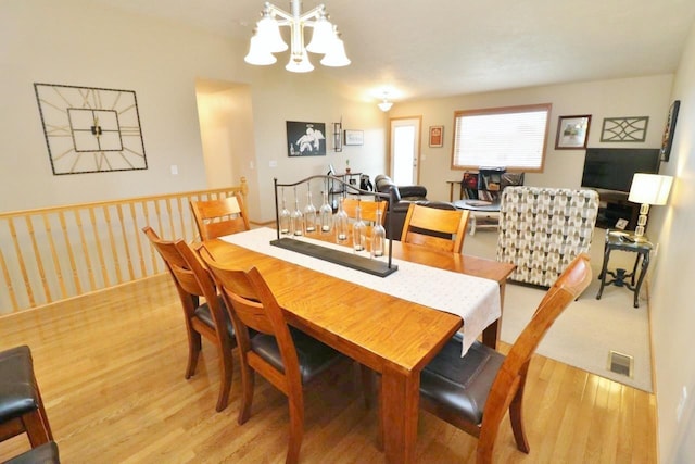 2033 14th St, Minot, ND 58703 - dining space with light wood-style flooring and a chandelier