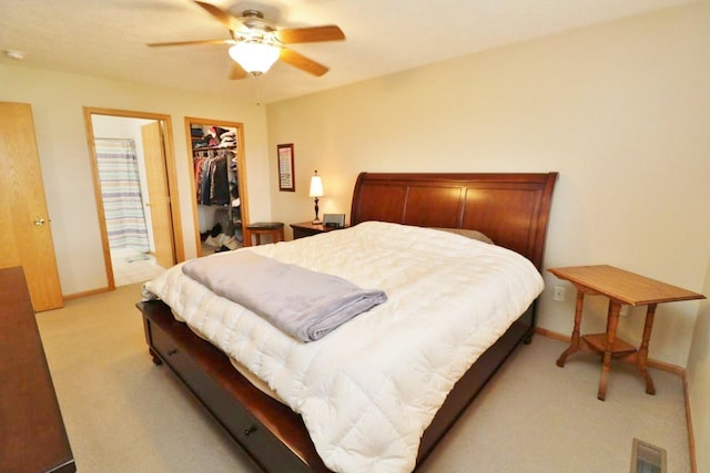 2033 14th St, Minot, ND 58703 - bedroom featuring light colored carpet, a spacious closet, a closet, and ceiling fan