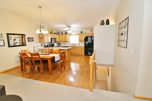 2033 14th St, Minot, ND 58703 - dining area featuring light wood-type flooring, a ceiling fan, and a chandelier