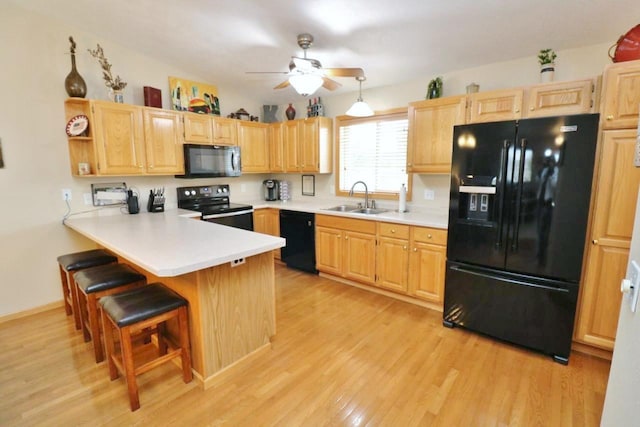 2033 14th St, Minot, ND 58703 - kitchen featuring black appliances, ceiling fan, light brown cabinetry, and light wood finished floors