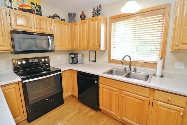 2033 14th St, Minot, ND 58703 - kitchen with black appliances, light wood finished floors, light countertops, and light brown cabinetry
