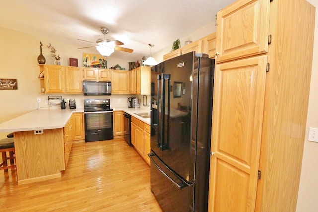 2033 14th St, Minot, ND 58703 - kitchen featuring black appliances, light brown cabinets, a peninsula, and light wood-style floors