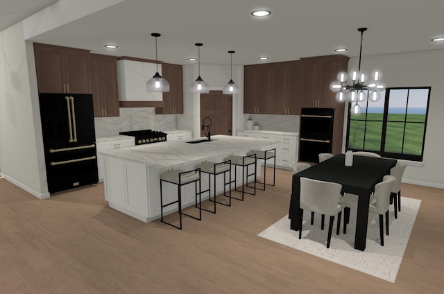 2610 43rd Ave, Minot, ND 58701 - kitchen featuring black appliances, tasteful backsplash, a kitchen island with sink, recessed lighting, and a kitchen bar