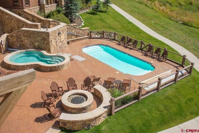 view of pool featuring a fire pit, a lawn, a hot tub, and a patio