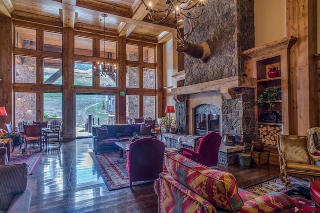 living room featuring a chandelier, a fireplace, beamed ceiling, a towering ceiling, and dark hardwood / wood-style floors