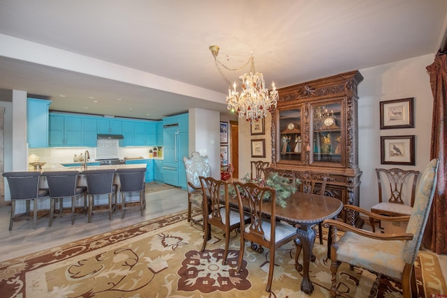 tiled dining room featuring sink and an inviting chandelier