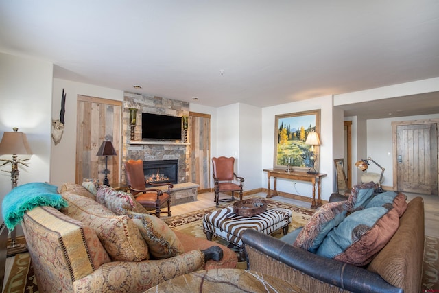 living room with a stone fireplace and light hardwood / wood-style flooring