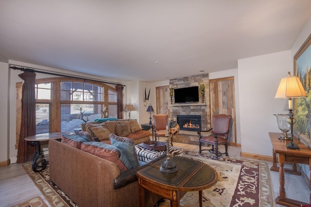 living room featuring a stone fireplace and light hardwood / wood-style flooring