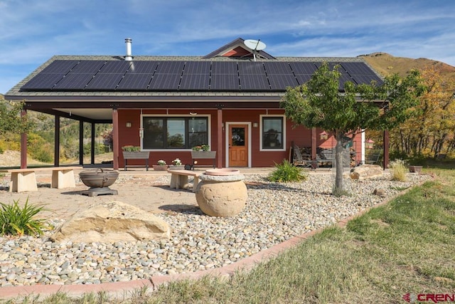 view of front of property featuring a fire pit and solar panels