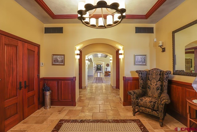 tiled foyer featuring a chandelier and a tray ceiling