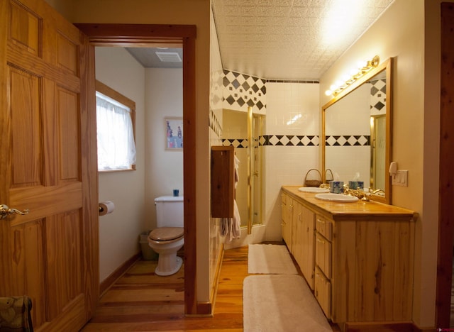 bathroom featuring wood-type flooring, toilet, and large vanity