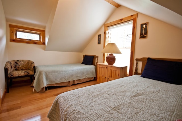 bedroom with vaulted ceiling and light hardwood / wood-style flooring