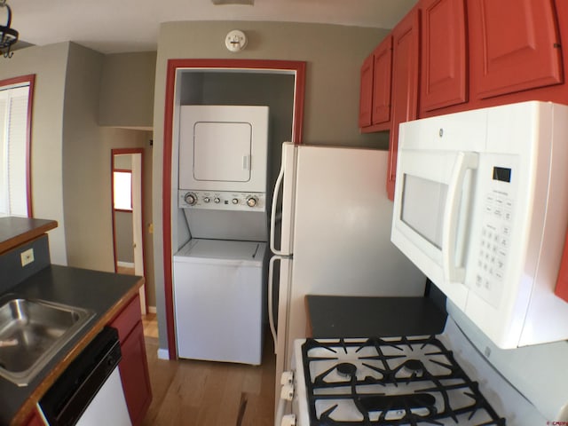 kitchen with light hardwood / wood-style flooring, sink, white appliances, and stacked washer / drying machine