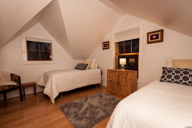 bedroom with lofted ceiling and wood-type flooring