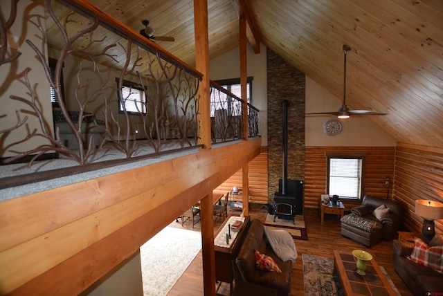 living room featuring wood ceiling, hardwood / wood-style flooring, high vaulted ceiling, log walls, and beamed ceiling