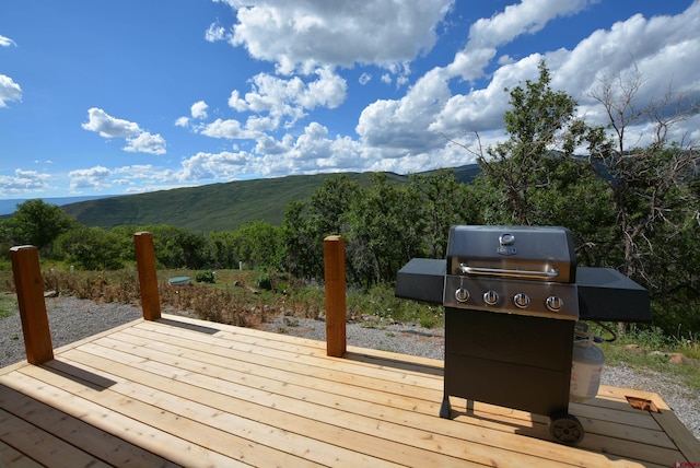 wooden deck with a mountain view and grilling area