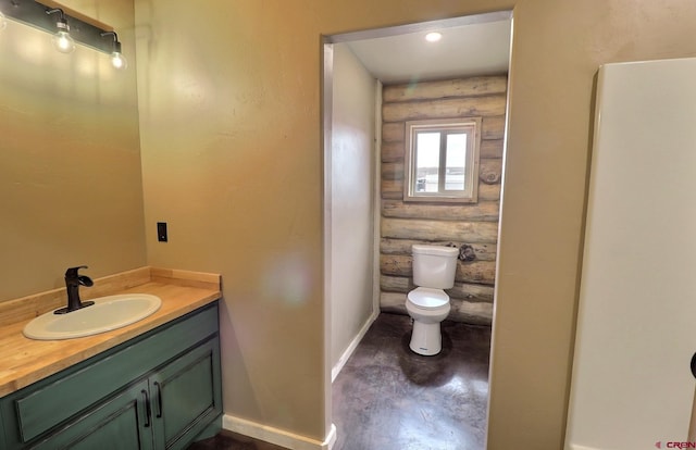 bathroom with log walls, toilet, and vanity