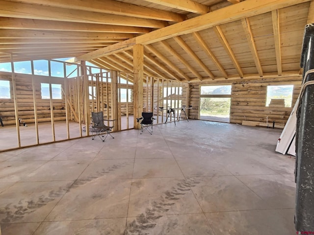 miscellaneous room featuring log walls, lofted ceiling, and a healthy amount of sunlight