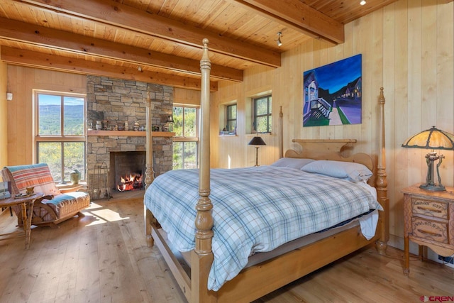 1006 Top Of The World Dr, Placerville, CO 81430 - bedroom with a fireplace, wood walls, and light wood-type flooring