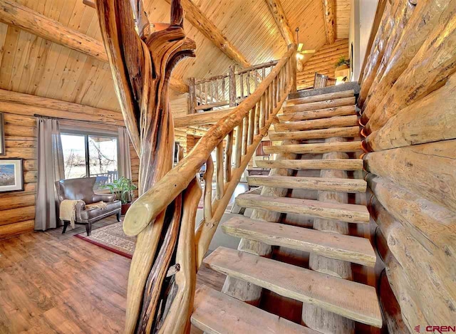 stairs featuring beam ceiling, wood-type flooring, rustic walls, and wooden ceiling