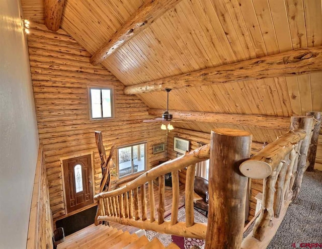 staircase featuring log walls, dark hardwood / wood-style flooring, ceiling fan, lofted ceiling with beams, and wood ceiling