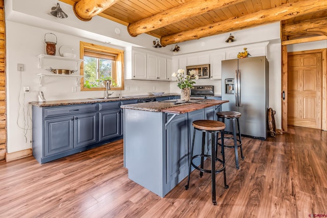 kitchen featuring a kitchen island, wood-type flooring, appliances with stainless steel finishes, white cabinetry, and sink