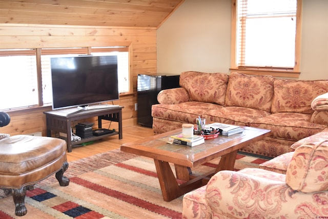 living room featuring wooden ceiling, wood walls, lofted ceiling, and light hardwood / wood-style floors