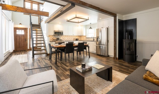 living room with dark hardwood / wood-style floors, beam ceiling, and plenty of natural light