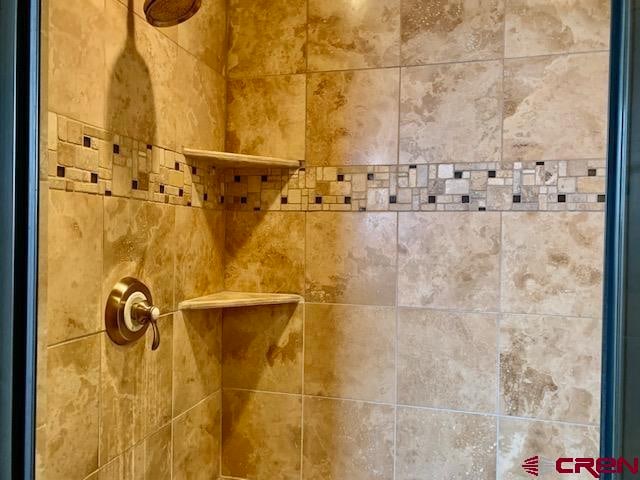 interior details featuring tiled shower