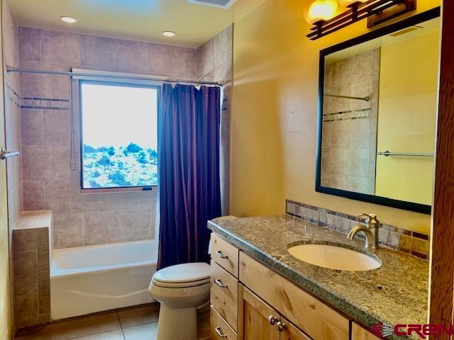 full bathroom with toilet, shower / bath combo with shower curtain, tile floors, and vanity