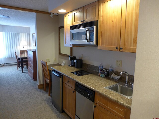 kitchen featuring a textured ceiling, sink, light colored carpet, and stainless steel appliances