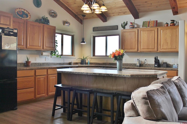 kitchen featuring a kitchen island, a chandelier, wooden ceiling, decorative light fixtures, and black fridge