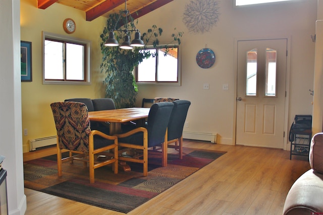 dining area with an inviting chandelier, a baseboard radiator, and light hardwood / wood-style flooring