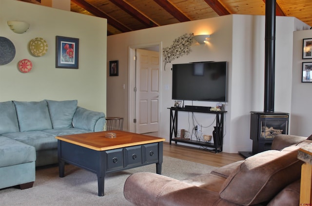 living room with light hardwood / wood-style flooring, a wood stove, wood ceiling, and lofted ceiling with beams