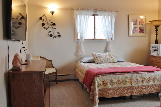 bedroom with carpet floors and a baseboard heating unit