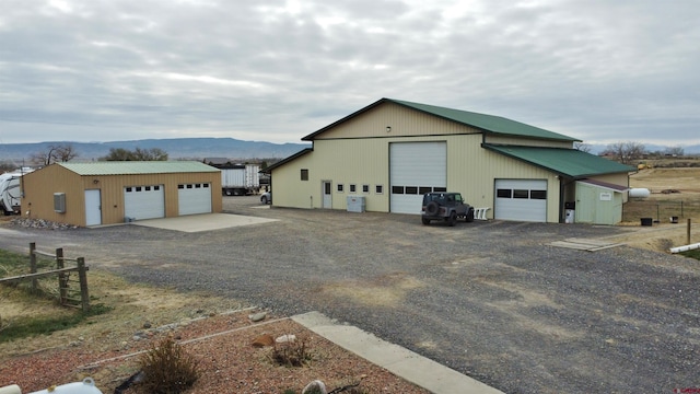 view of front facade featuring an outdoor structure, a mountain view, and a garage