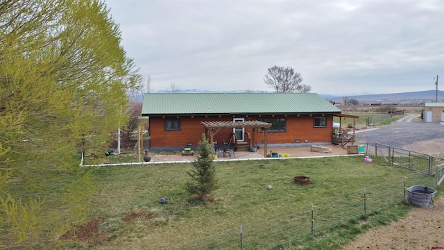 rear view of property featuring a lawn and a patio area