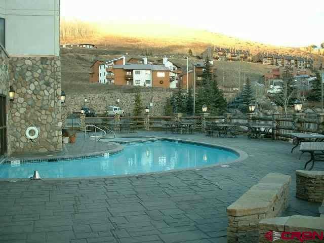 pool at dusk featuring a patio