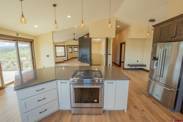 kitchen featuring white cabinets, dark stone countertops, premium appliances, ceiling fan, and lofted ceiling