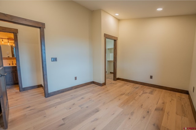 spare room featuring sink and light hardwood / wood-style floors