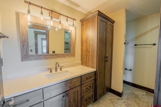 bathroom featuring tile flooring, toilet, and vanity