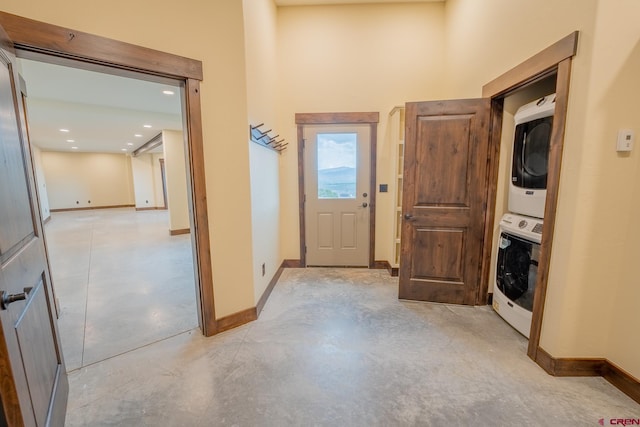 corridor featuring stacked washer / dryer and a towering ceiling