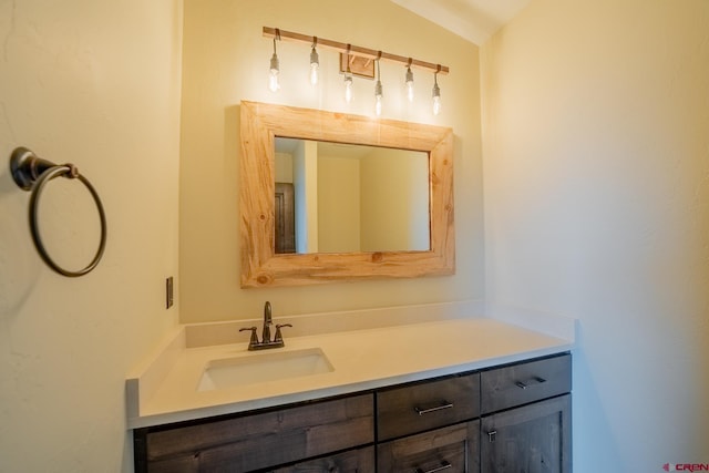 bathroom featuring lofted ceiling and vanity