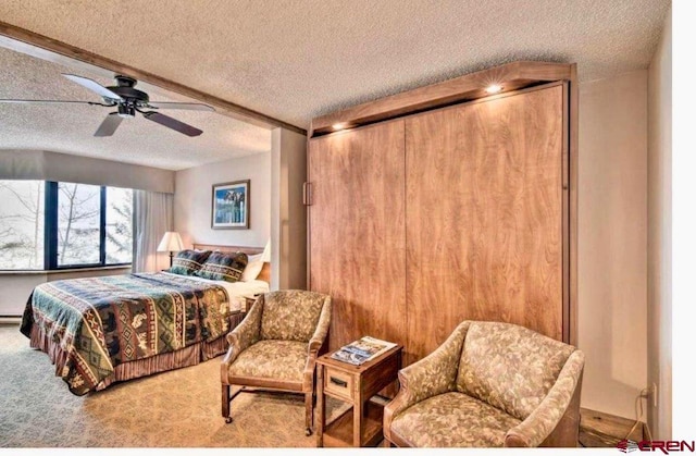 bedroom with ceiling fan, a textured ceiling, and carpet flooring