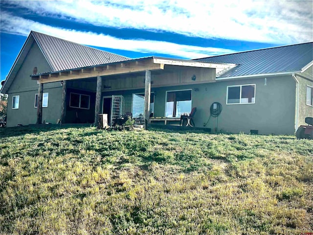 rear view of property featuring a yard