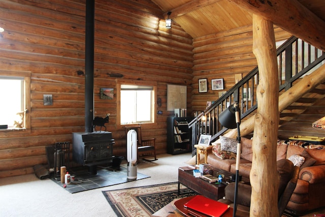 carpeted living room featuring a wood stove, beam ceiling, log walls, high vaulted ceiling, and wood ceiling