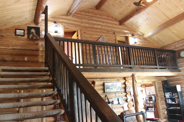 stairway with wood ceiling, rustic walls, beamed ceiling, and high vaulted ceiling