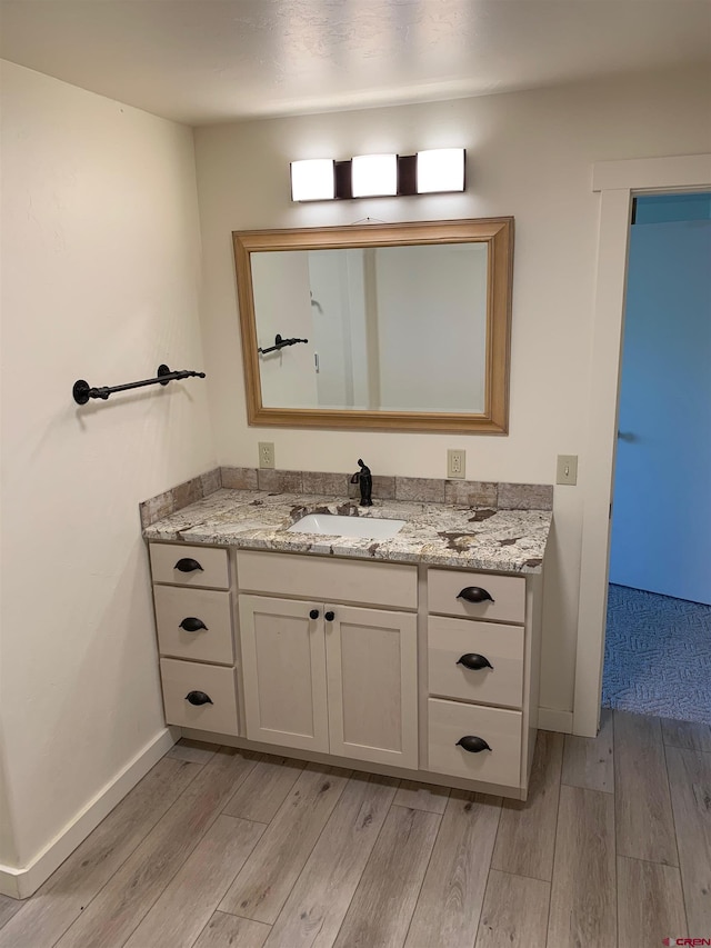 bathroom with hardwood / wood-style flooring and vanity