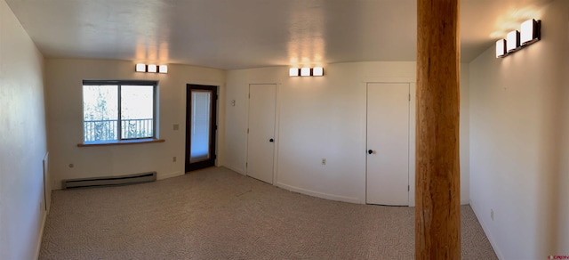 carpeted spare room featuring a baseboard radiator