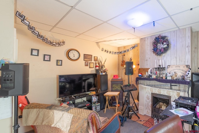 carpeted living room with a drop ceiling and a premium fireplace